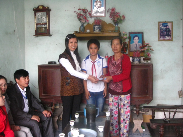 Cô giáo Nguyễn Thị Thương - phó hiệu trưởng nhà trường trao quà cho gia đình ông Bùi Văn Sáu